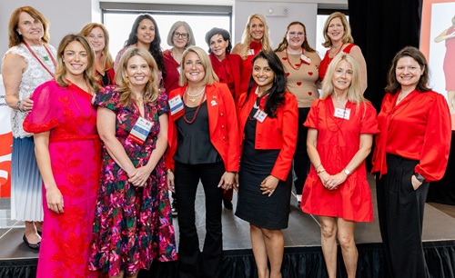 Large group of women wearing red standing in tiered rows.